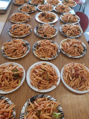 Veertien borden met pasta op een tafel